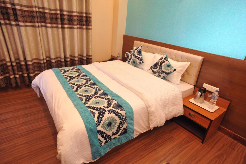 een slaapkamer met een groot bed met een houten hoofdeinde bij Hotel Arati Pvt. Ltd. in Kathmandu