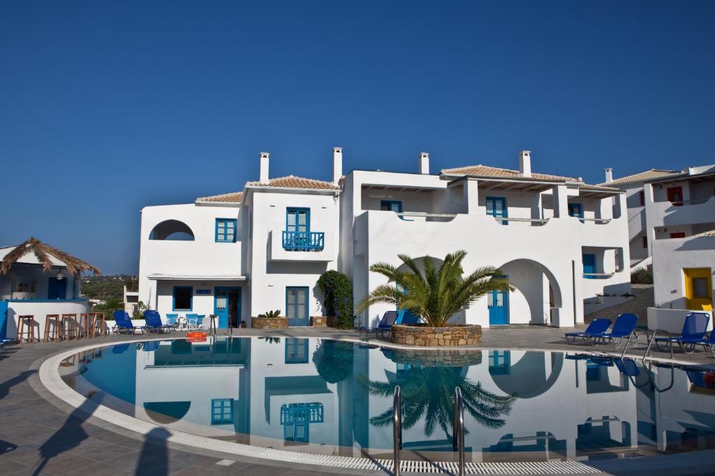 a swimming pool in front of a white building at Viva Mare Foinikounta in Finikounta