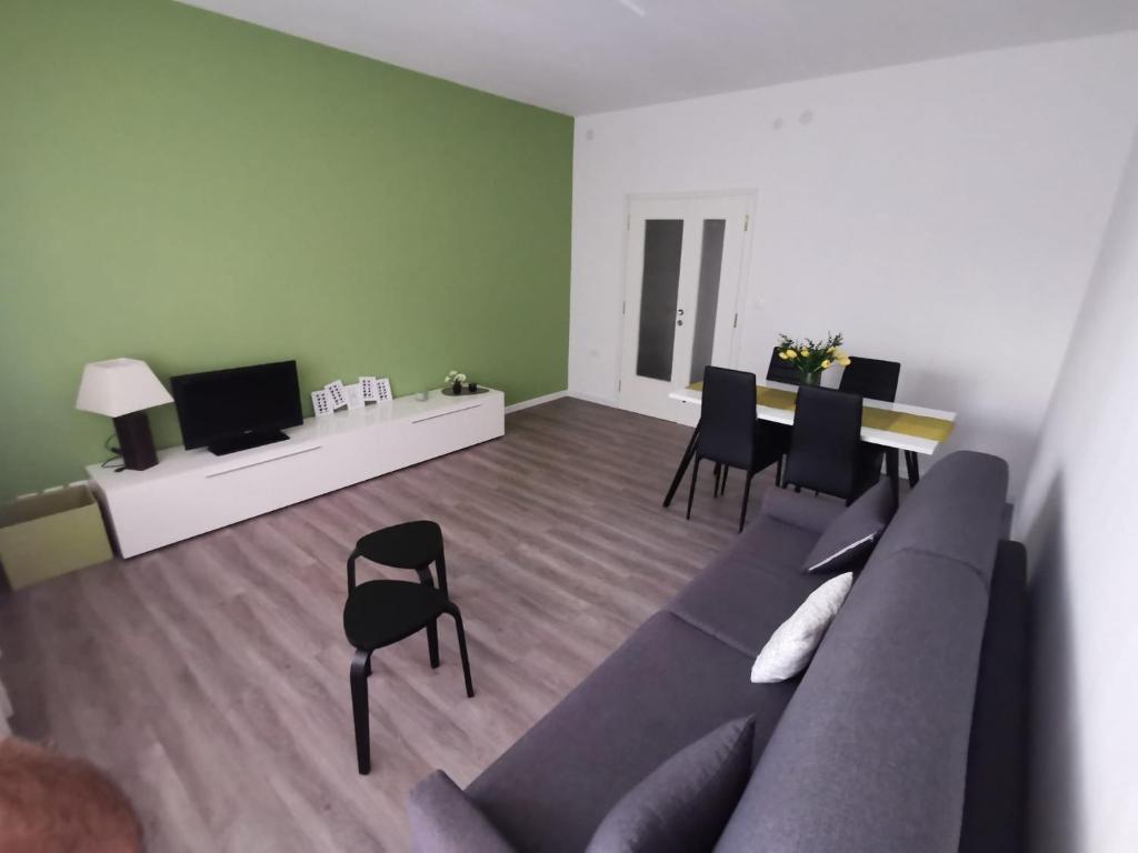 sala de estar con sofá, mesa y sillas en Terra di Mezzo, en Gorizia