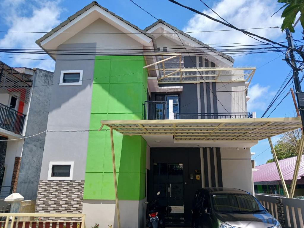 uma casa pintada de verde e branco em OYO 93085 Homy Stay Syariah em Balikpapan