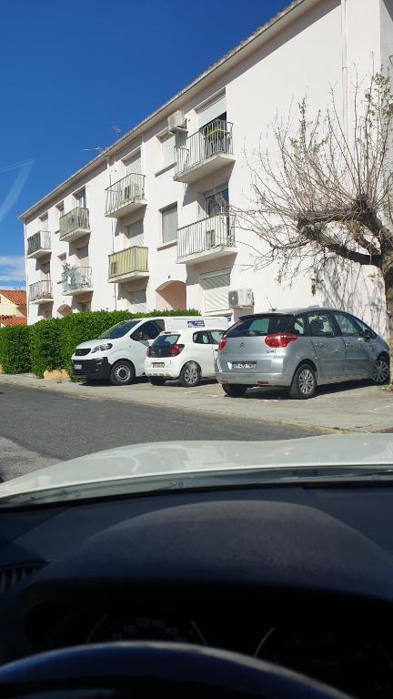 un groupe de voitures garées devant un bâtiment dans l'établissement Appartement 3 pièces, au Boulou