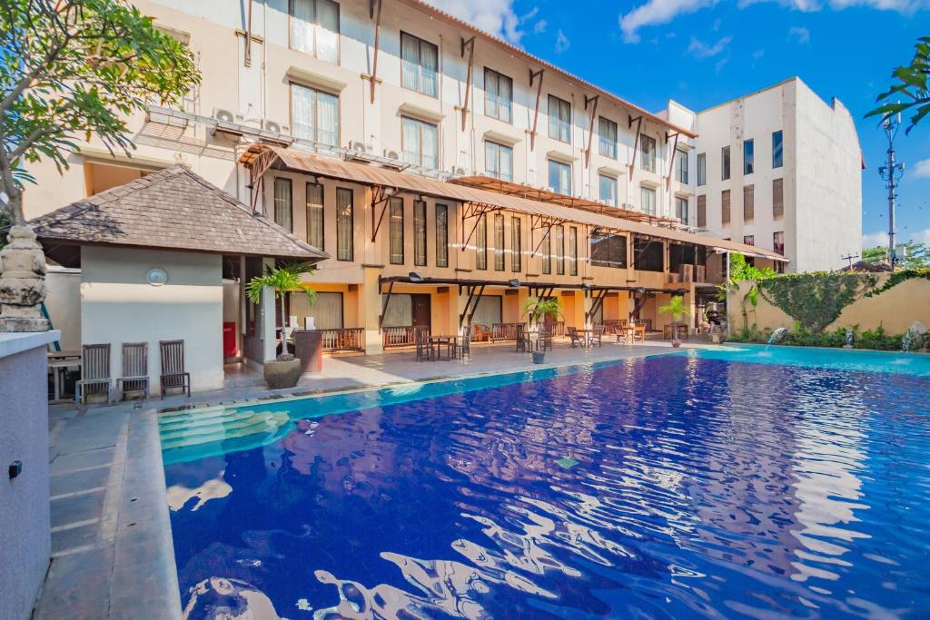 a large swimming pool in front of a building at Grand Santhi Hotel in Denpasar
