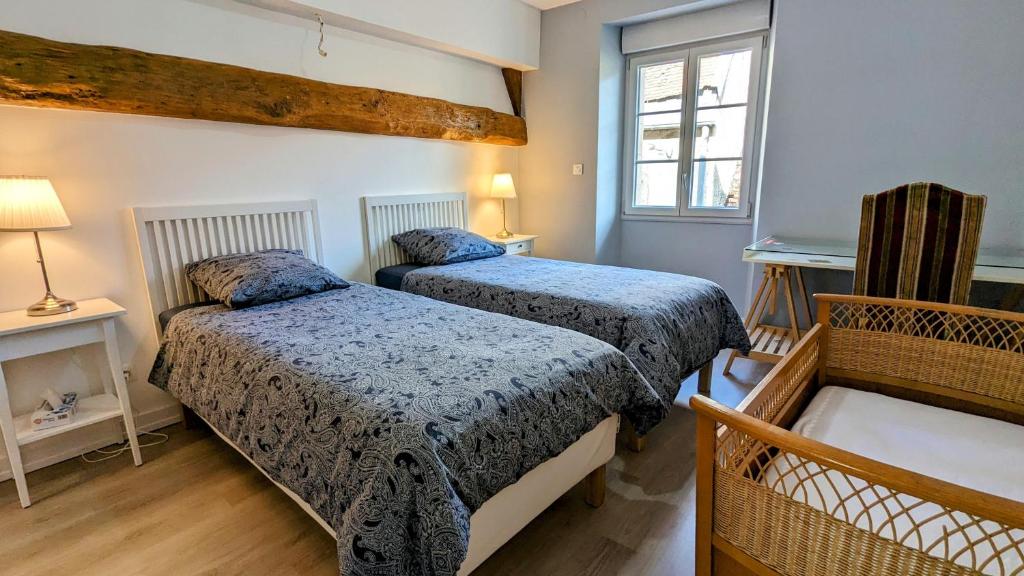 a bedroom with two beds and a window at La Tuilerie in Bèze