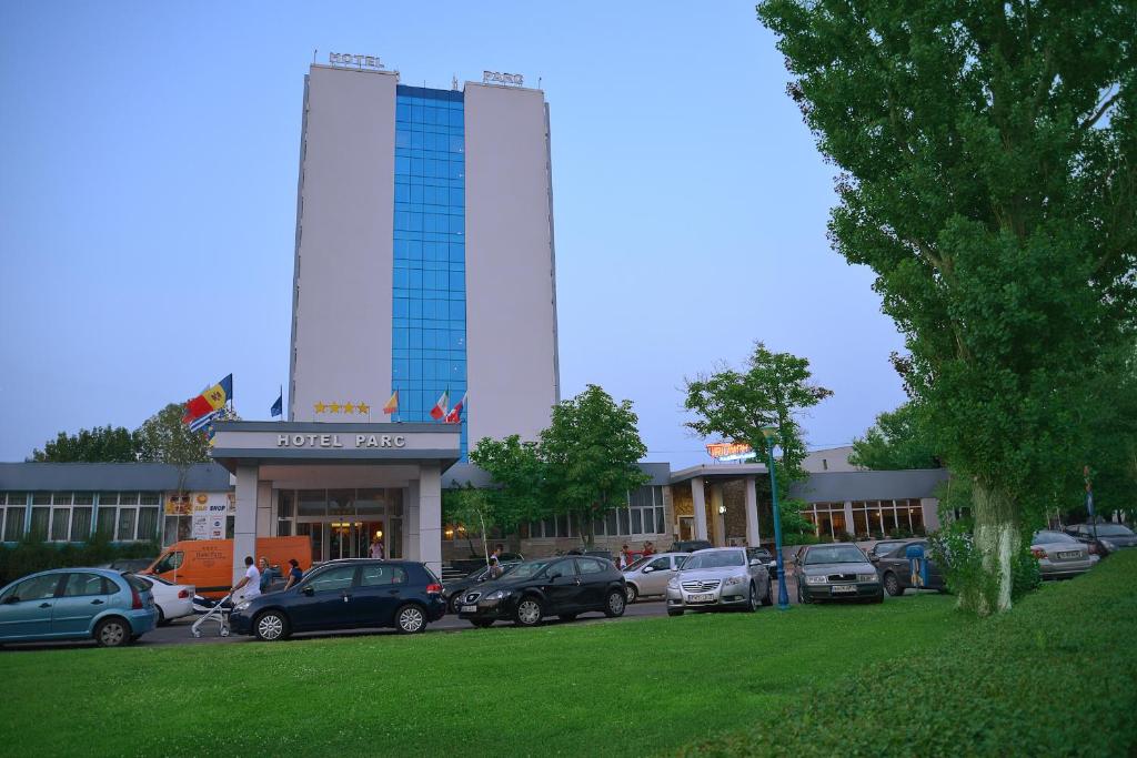 a large building with cars parked in a parking lot at Hotel Parc in Mamaia