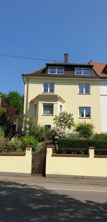 una gran casa amarilla con una valla delante en Haus am Berg, en Neunkirchen