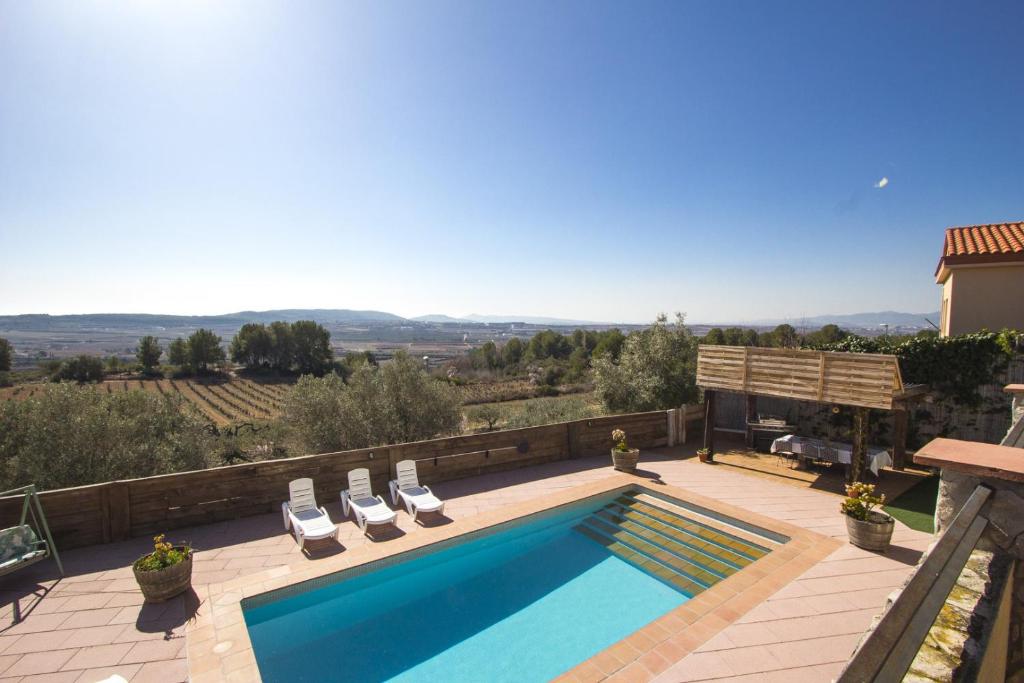 a swimming pool with two lounge chairs next to a house at Catalunya Casas Indoor and Outdoor Pools, Sauna, Gym, Games Area in Sant Pau dʼOrdal