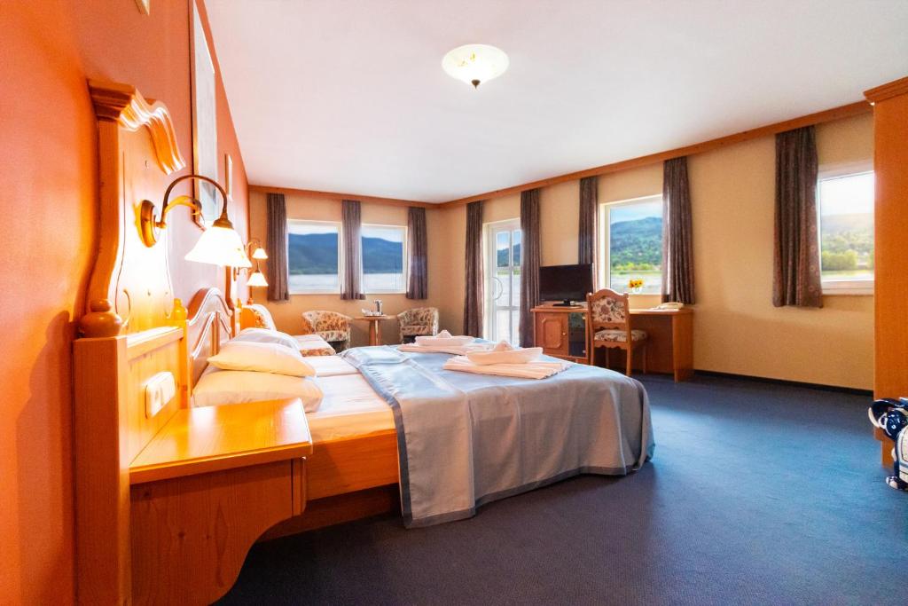 a hotel room with a bed and a desk at Aquamarina Hotel Visegrád in Visegrád