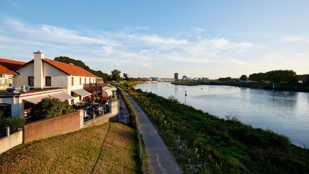 een uitzicht op een rivier met gebouwen naast een rivier bij Valuas in Venlo