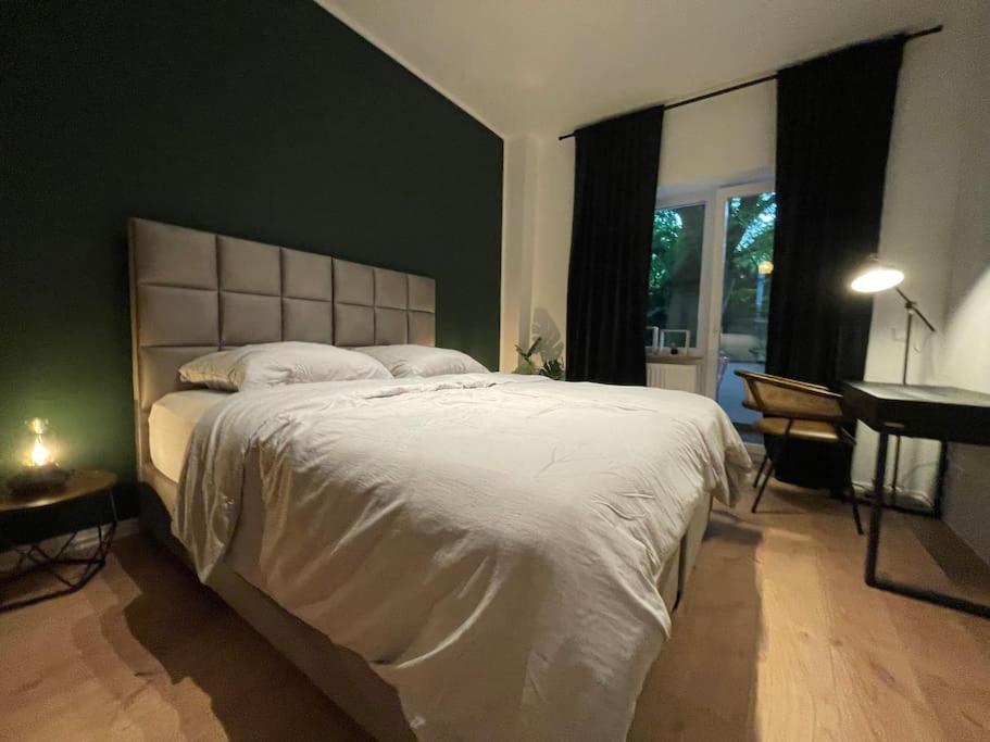 a bedroom with a large white bed and a desk at Central•Balcony•Messe•Uniklinik perfect for 2 in Essen