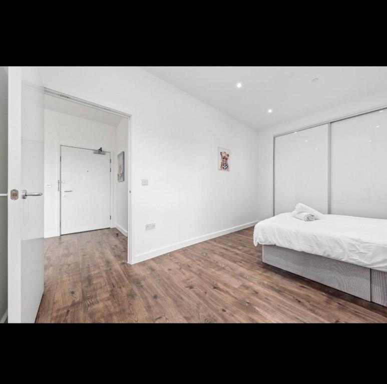 バジルドンにあるCharming 1 Bedroom Flat in Essex TH620の白いベッドルーム(ベッド1台、大きな鏡付)