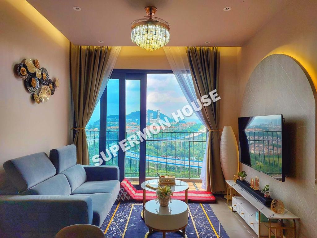 ein Wohnzimmer mit einem blauen Sofa und einem großen Fenster in der Unterkunft Aster Residence, Cheras Luxury Family Suite 3R 3B - Direct MRT Link in Kuala Lumpur