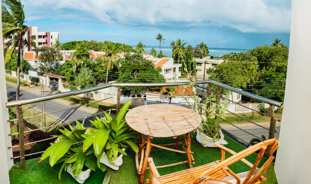 een balkon met een tafel en stoelen en uitzicht op de stad bij ZaNaKri Homes ;A Great Panorama of Indian Ocean in Mombasa