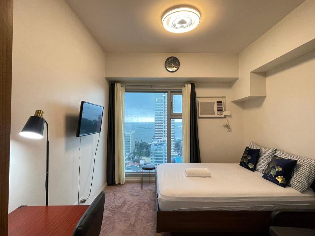 a bedroom with a bed and a window with a view at 8 Adriatico in Manila