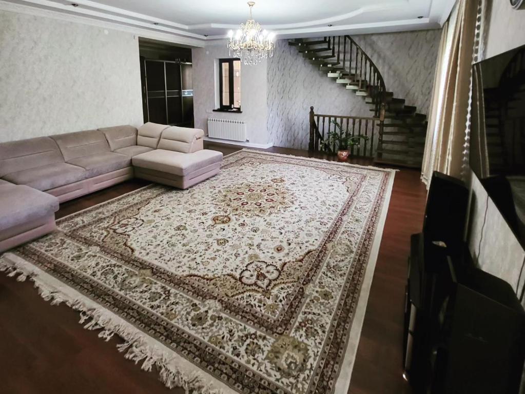 a living room with a couch and a rug at Almaty guest house in Almaty