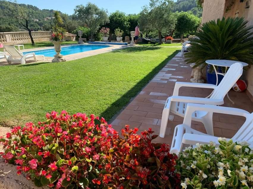 a garden with white chairs and flowers next to a pool at Coatmeur brunette jean marie in Cabasse