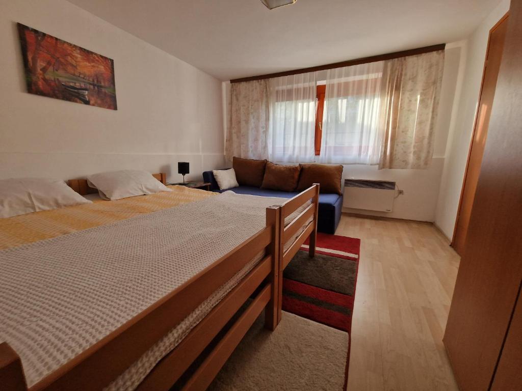 um quarto com uma cama grande e um sofá em Apartment near center em Sarajevo