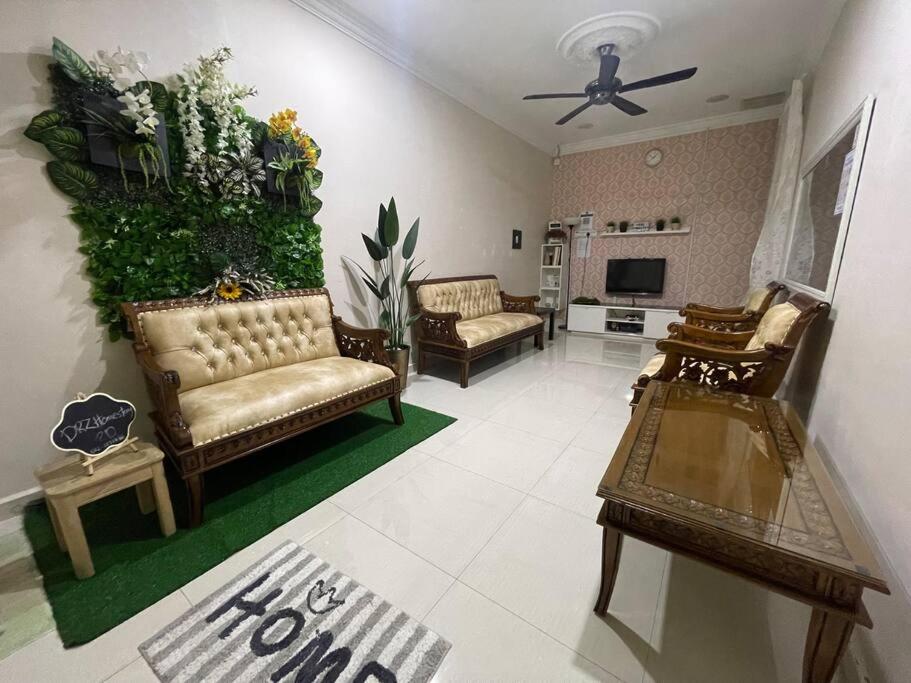 una sala de estar con sofás y una pared verde en 3Bedroom Full AirCond House with Pool@PortDickson, en Port Dickson