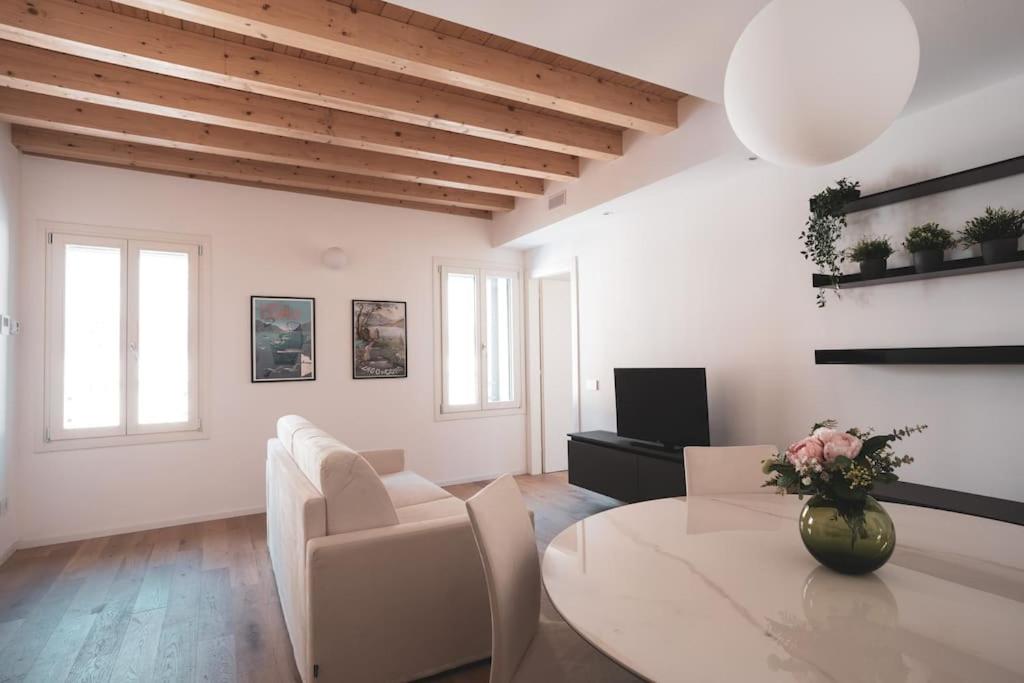 un soggiorno bianco con tavolo e sedie di Modern Apartment Lungolago di Como a Como