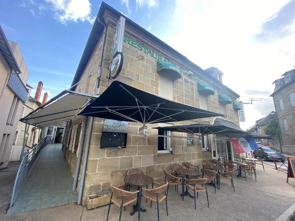 een groep tafels en stoelen voor een gebouw bij la terrasse in Larche