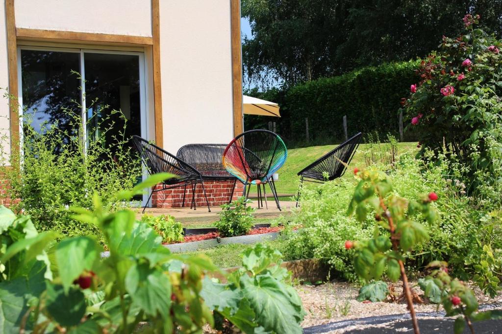 a garden with two chairs on a porch at Maison Mélèry in Saint-Pierre-du-Val