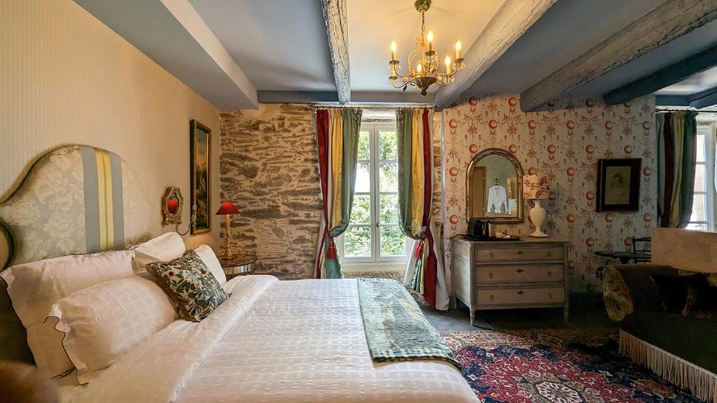 a bedroom with a bed and a dresser and a mirror at LA GALANTE in Faugères