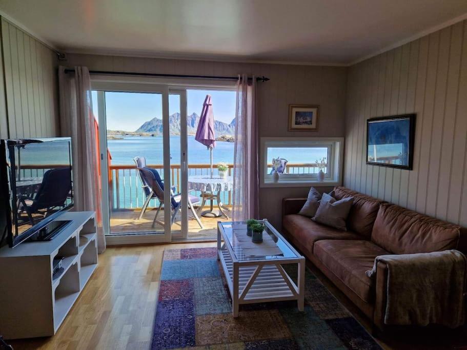 a living room with a couch and a view of the ocean at Tobiasbua in Svolvær