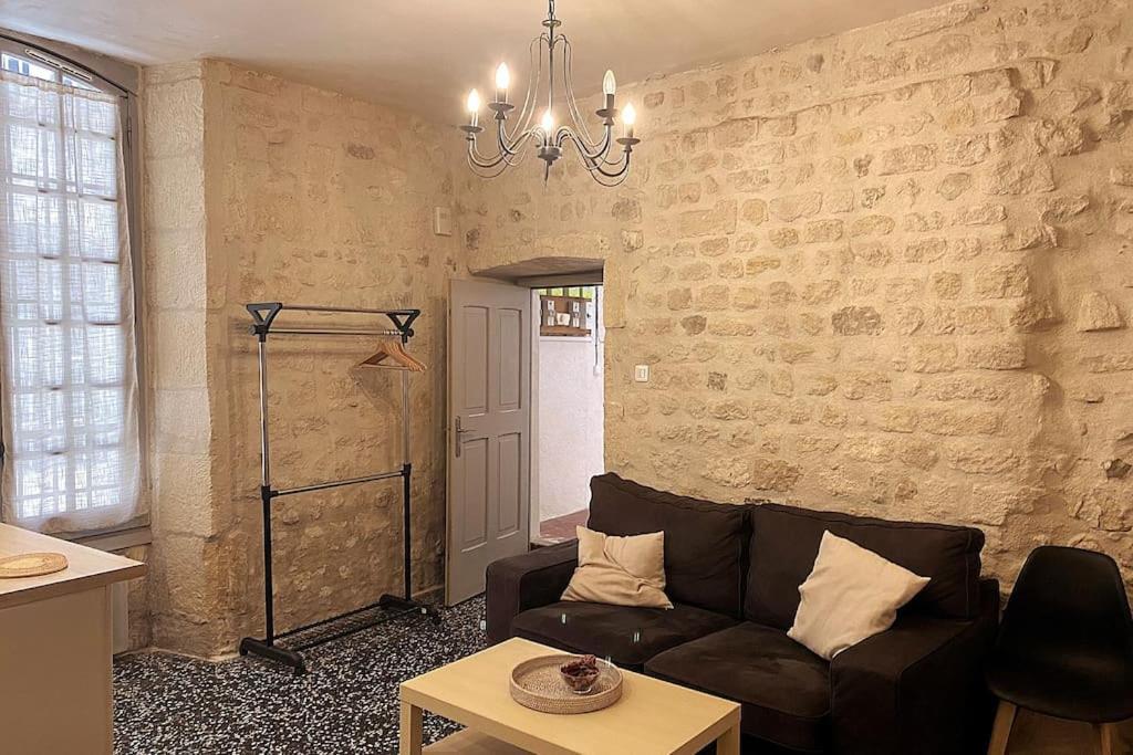 sala de estar con sofá y pared de ladrillo en Appartement au coeur du quartier de la Roquette, en Arles