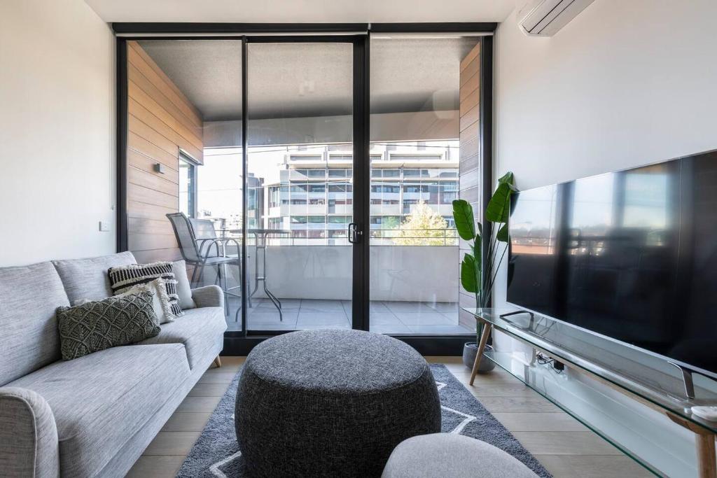 salon z kanapą i telewizorem w obiekcie Stunning Modern Style with a Gym, Pool and Spa w Melbourne