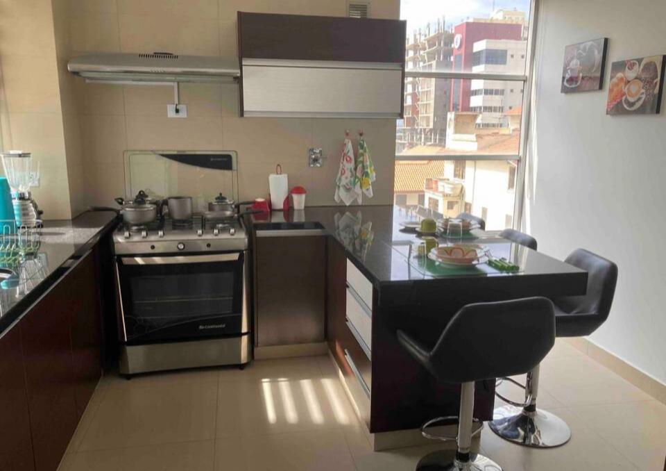 Il comprend une cuisine équipée d'une cuisinière et d'une chaise. dans l'établissement Bonito apartamento Cocha, à Cochabamba