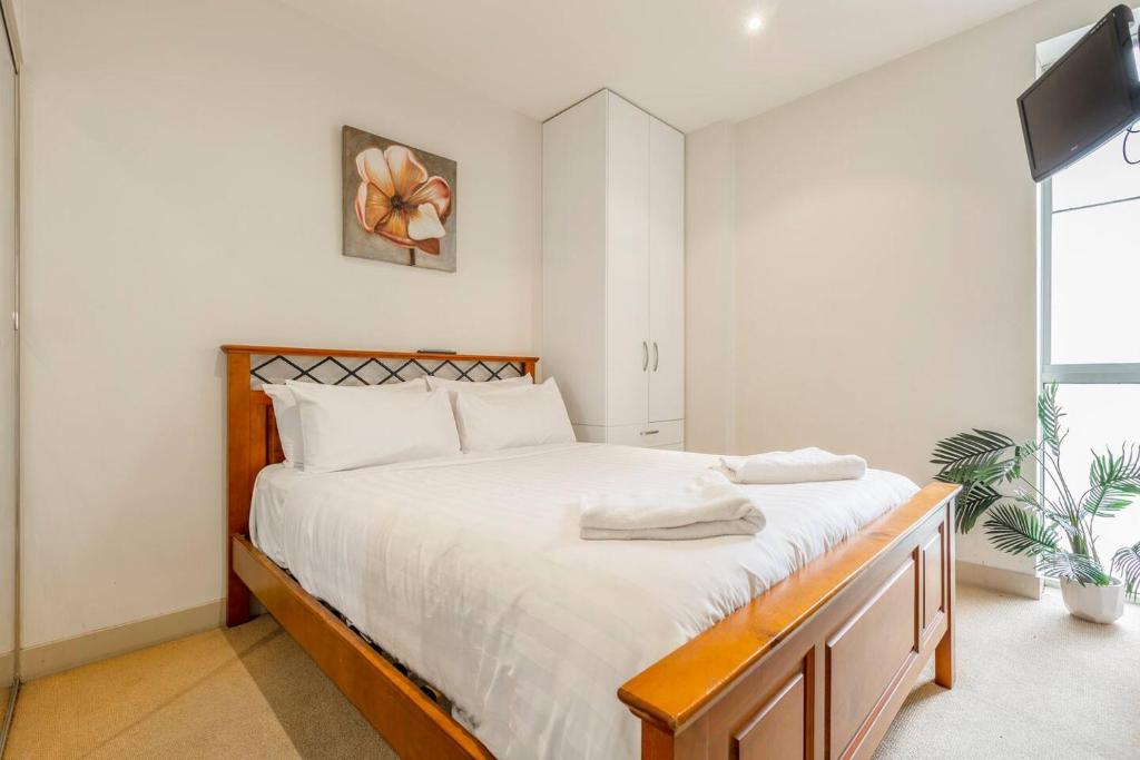 ein Schlafzimmer mit einem großen Bett und einem TV in der Unterkunft Location meets Comfort near Bourke Street Mall in Melbourne