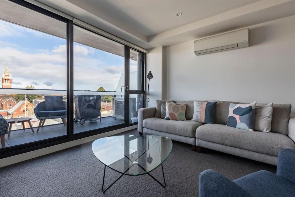 sala de estar con sofá y mesa de cristal en Light-filled Stylish Living in Diverse Hawthorn, en Melbourne