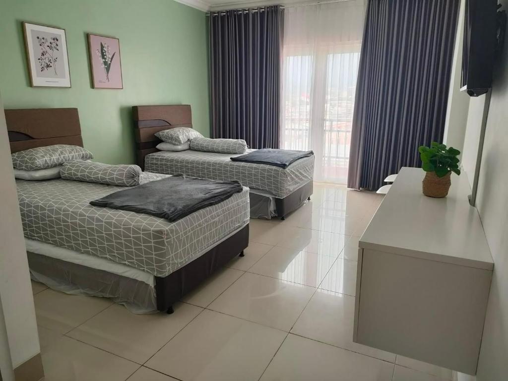 1 dormitorio con 2 camas y ventana grande en Apartemen MTC Unit 626 en Manado