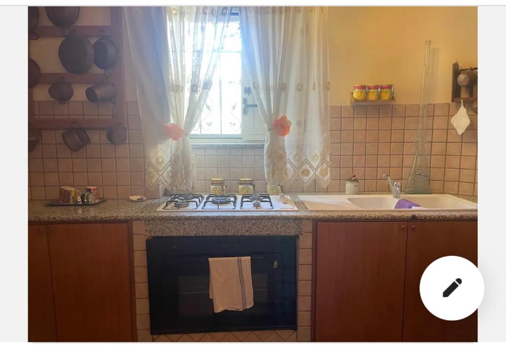 uma cozinha com um fogão, um lavatório e uma janela em Mamma Rosaria em Pompeia