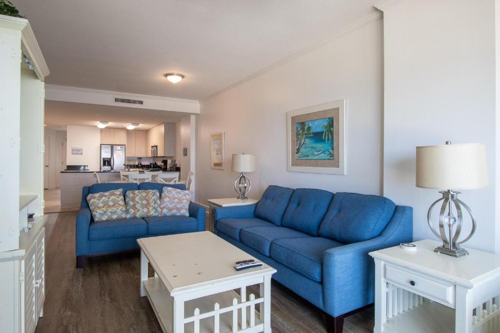 een woonkamer met twee blauwe banken en een tafel bij Sea Breeze 908 in Biloxi