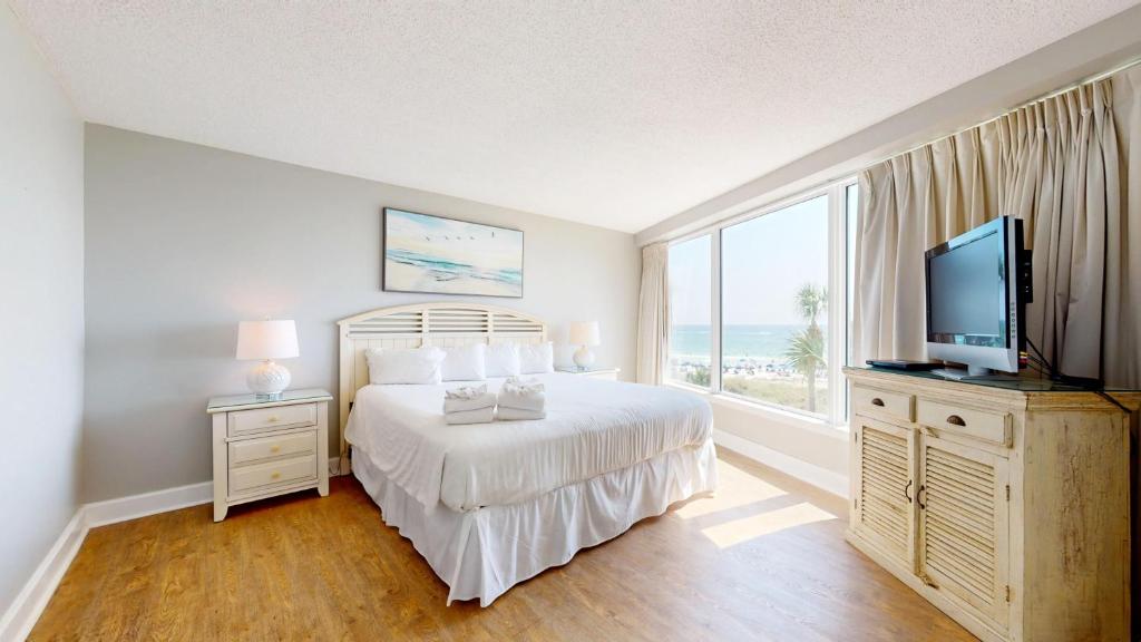 a bedroom with a bed and a television and a window at Beachside II 4226 in Destin