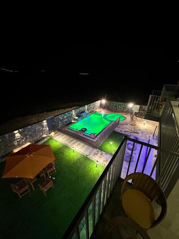 a view of a swimming pool at night at JA view chalet in Duwaykhīlah