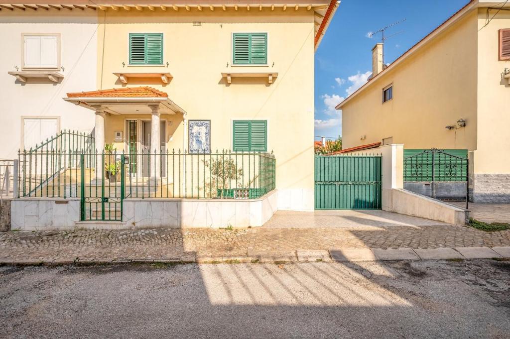 a house with a green gate in front of it at GuestReady - Pleasant Stay in Encarnação in Lisbon