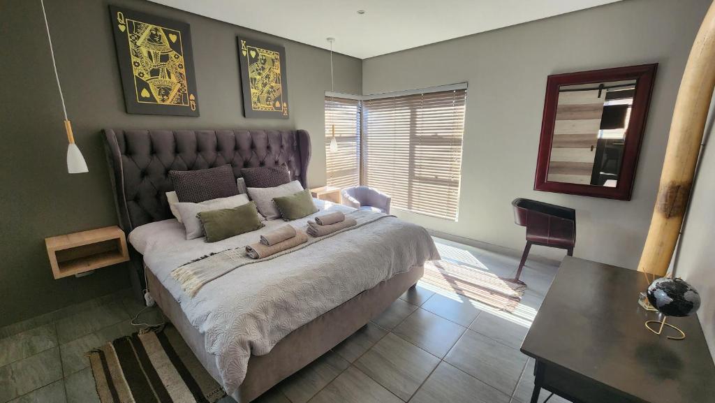 een slaapkamer met een groot bed en een tafel bij @Lloyds in Ermelo