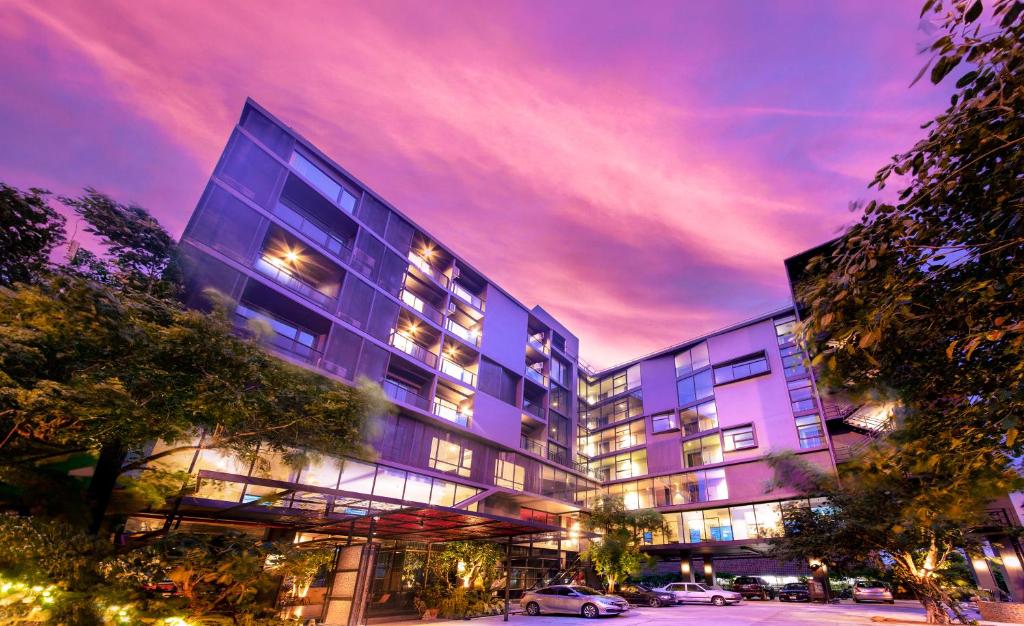 a large building with a parking lot in front of it at Sibtis Hotel in Lampang