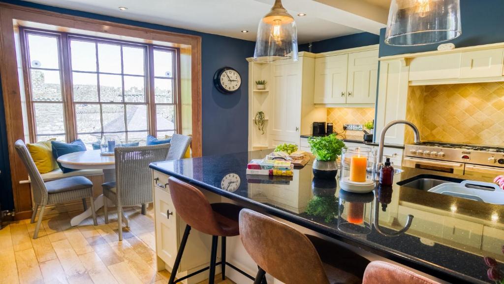 a kitchen with a counter and a dining room at Ty Castell in Beaumaris