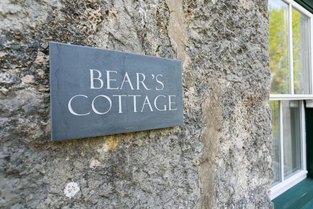 a sign on the side of a building that reads bears coffee at Bears Cottage in Moelfre