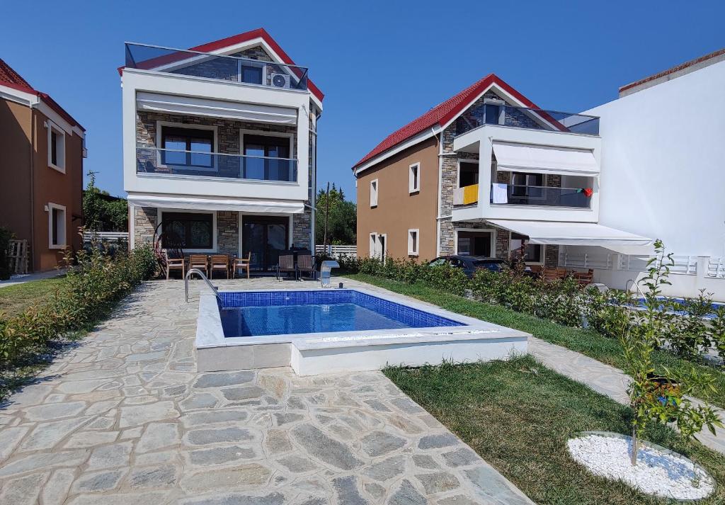 une maison avec une piscine dans la cour dans l'établissement VILLA CASSIOPEIA, à Nikiti