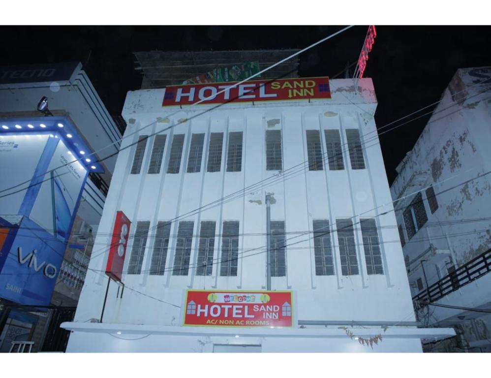 HOTEL SANDS INN, Jodhpur في جودبور: مبنى ابيض كبير عليه لافته للفندق