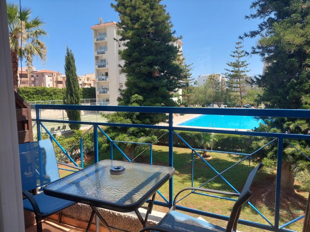 un balcone con tavolo, sedie e piscina di Palm Beach Apartment 26 a Limassol