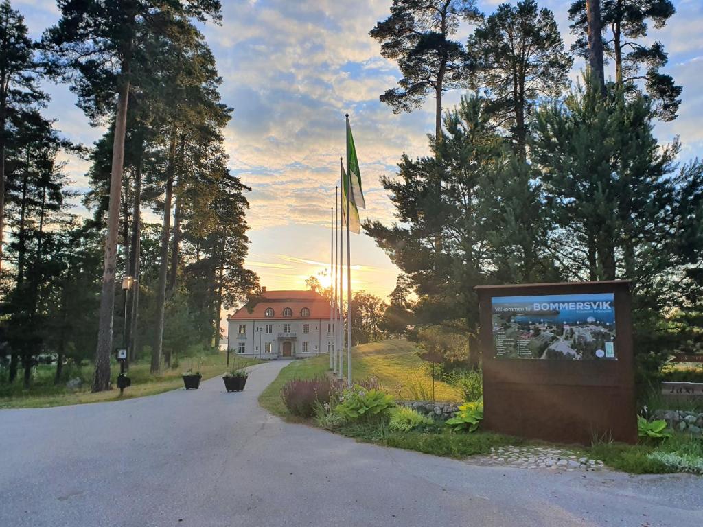 un edificio en medio de una carretera con una señal en Bommersvik Hotell & Konferens, en Järna