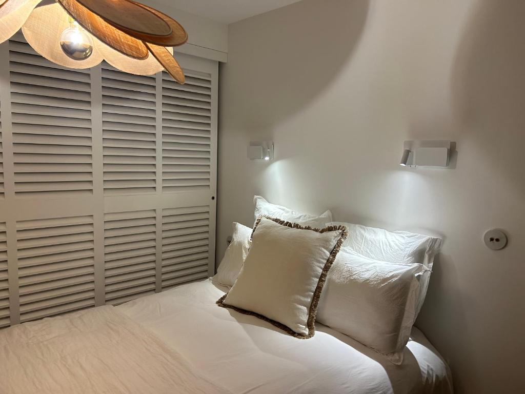Un dormitorio con una cama con almohadas blancas y una ventana en L'OUSTAOU BELLO VISTO, en Le Castellet