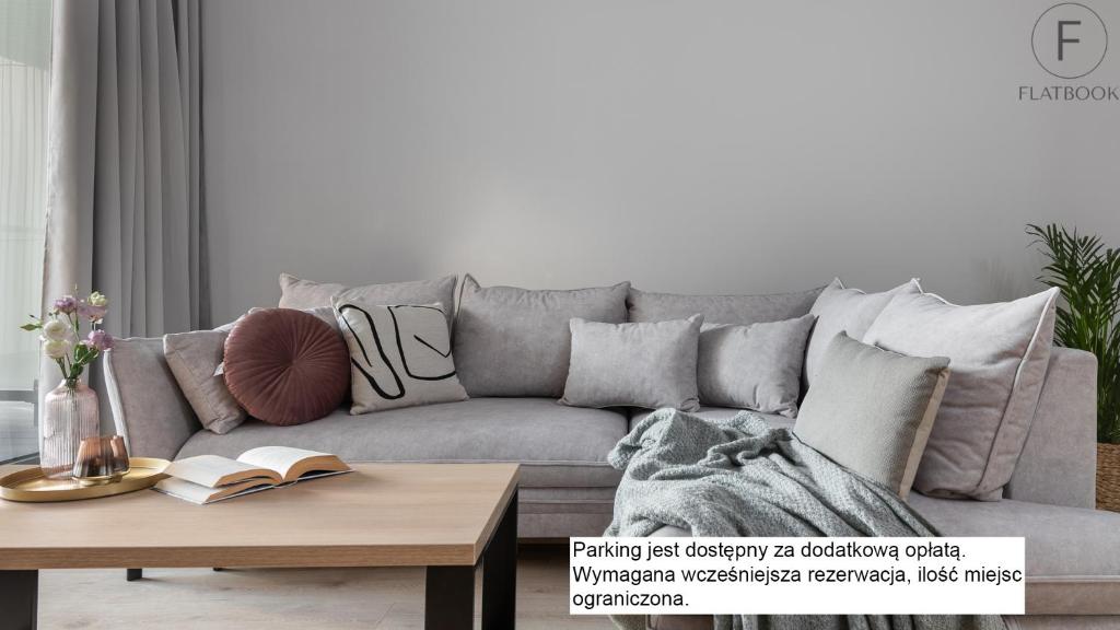 a grey couch in a living room with a coffee table at Flatbook - City Center Apartments Granaria in Gdańsk