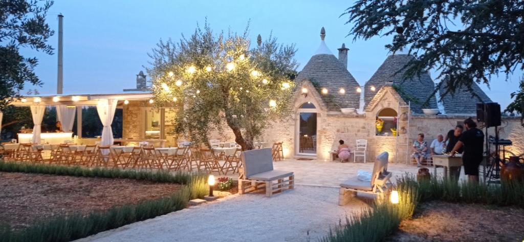 una casa con patio attrezzato con sedie e luci di La Relais del Trullo a Putignano