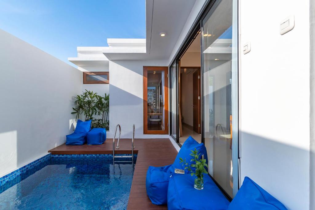 una piscina en una casa con almohadas azules en Astungkara Bali Villa, en Tabanan