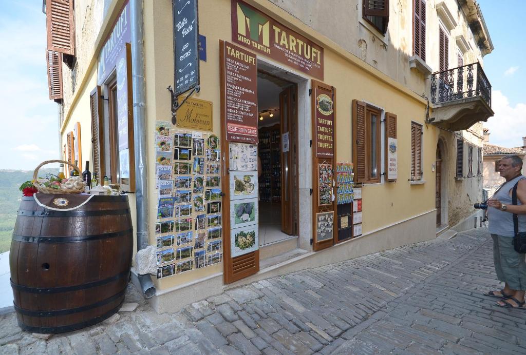 a man standing in front of a building with a barrel at Bella Vista Apartments in Motovun